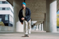 Portrait of active skater boy balancing on skateboard on urban background Focused skateboarder moving on skate board outdoor.