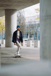 Portrait of active skater boy balancing on skateboard on urban background Focused skateboarder moving on skate board outdoor.