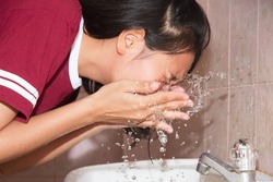 Asian woman face wash at basin