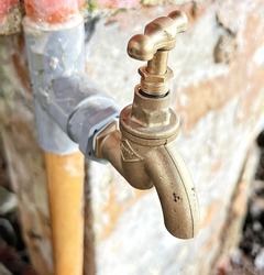 Blurred background image of water tap with rubber hose. Used for watering vegetables in the garden.