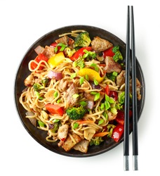 Plate of noodles with meat and vegetables isolated on white background, top view
