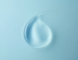 transparent gel drop on blue background, top view