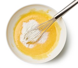 bowl of mixed egg yolks and sugar with corn starch for making custard cream isolated on white background, top view