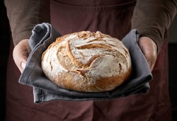freshly baked bread in bakers hands