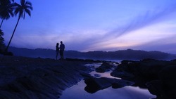Couple holding hands waiting sunrise on beach