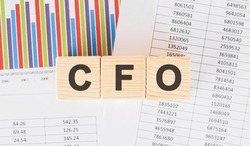 cfo word written on wood block. Faqs text on table, concept.