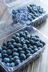 Blueberries in a transparent plastic box. New crop. Freshly picked berries. 