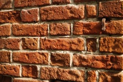 Fragment of a ceramic brick wall with white masonry mortar, white masonry seams, close-up.