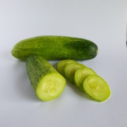 Cheap fresh cucumber with some cucumber slices isolated on white background.  cheap groceries.