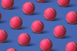 Pattern with pink tennis balls on a dark blue background. Creative sport concept. Flat lay, top view. Сreative colorful pattern with tennis balls.