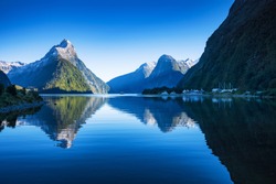Clear sky in Milford sound, Fjordland national park, south island, New Zealand with a reflection of Mitre peak in the water.