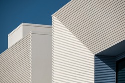 Detail of a white and blue modern villa in a Middle Eastern, high-end, luxury housing development on a sunny day with strong shadows.