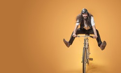 Funny crazy man riding a bike, on studio background