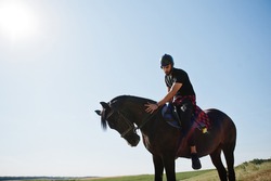 Arab tall beard man wear in black helmet, ride arabian horse.