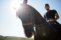 Arab tall beard man wear in black helmet, ride arabian horse.