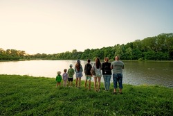 Big and large family against lake in sunrise. Six children. Parents and kids.