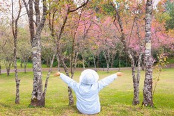 Girl wearing winter coat in sakura garden.
