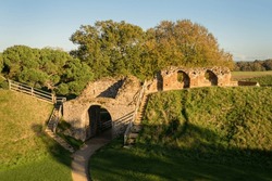View of arched entrace and moat bank to Castle Rising, Kings Lynn, Norfolk, England.