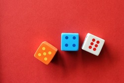 3 rubber dices on a red paper background.