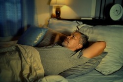 depressed old man and stressed lying in bed from insomnia