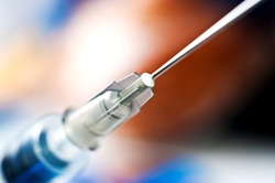 Syringe with needle on blur background