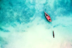 boat and ship in beautiful turquoise ocean near an island, top view, aerial photo