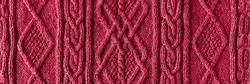 Knitted magenta background. Large knitted fabric with a pattern. Close-up of a knitted blanket. Demonstrating the colors of 2023 - Viva Magenta.