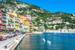 Panoramic view of coastline and beach with blue sky, luxury resort and bay with yachts, Nice port, Villefranche-sur-Mer, Nice, Cote d'Azur, French Riviera.