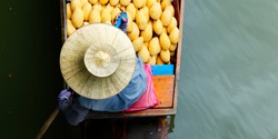 Woman trading fruit and food in boats at Damnoen Saduak floating market ,Thailand
