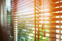 Wooden shutters blinds with sun rays. Window blinds. 