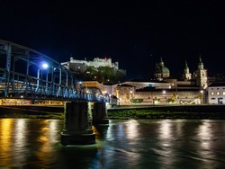 Night view over Salzach river with Mozartsteg to Hohensalzburg castle and old town in Salzburg, Austria