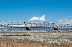 Shinkansen on Fujikawa Bridge pass in front of Mt. Fuji in Shizuoka.