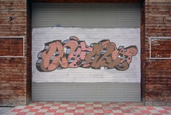 Corrugated metal sheet background, Street art of graffiti painted with spray paint on white painted Slide door on wooden walls, two empty frames on both sides. Urban contemporary culture.