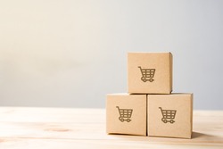 Online shopping ,Shopping cart logo on boxes on wooden table.