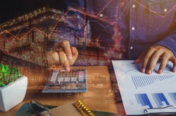 close up asian man calculate banking finance or saving economy background.Double exposure industrial offshore oil and gas platform for cost and growth up business on table office desk with accessories