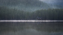 cabin in a misty forest near a lake