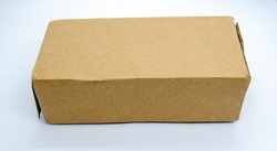 Lightly crumpled closed cardboard box parcel and isolated on a white background. Damaged postage cracked brown corrugated cardboard box from top side angle for product or gift packaging.
