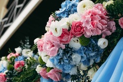 Bouquets of blue, white, pink and red flowers adorn the wedding venue at the entrance to the restaurant.