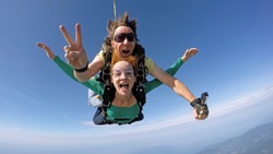 Skydive tandem happiness couple over the sea
