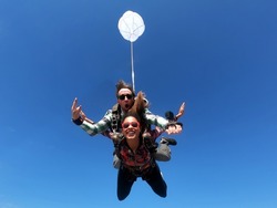 Skydiving tandem parachute jump. Beautiful fashion woman.