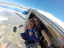 Skydiving. Happy Instructor and student screaming in aircraft door.
