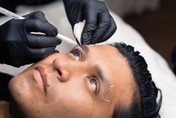 detail of outlining of eyebrows of a latin man before the micro pigmentation procedure