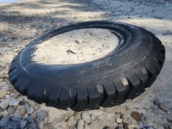 Car or Truck Tire Laying on Beech with Sand inside