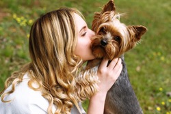 

The girl kisses the beloved Yorkshire terrier