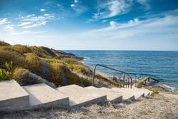
Stairs and wooden pier along the shore in the natural area, sunny autumn day.