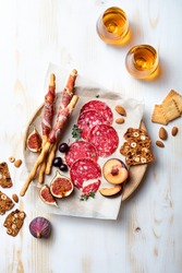 Appetizers table with italian antipasti snacks. Brushetta or authentic traditional spanish tapas set, cheese and meat variety board over wooden background. Top view, flat lay