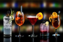 Selection of cocktails martini spritz bramble gin tonic bar blurred background