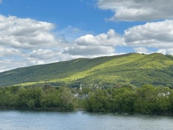 Allegheny Mountains of the Appalachian Mountain Range above the West Branch of the Susquehanna River in Williamsport, Pennsylvania.  Lycoming County.  A church steeple rises in the distance.