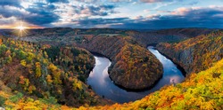 Panoramic view of river canyon with dark water and autumn colorful forest. Horseshoe bend, Vltava river, Czech republic. Beautiful landscape with river. Maj lookout.