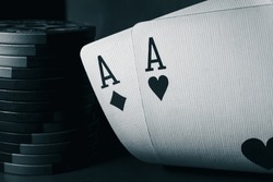 A pair of aces and poker chips, black and white photo. Ace of hearts and ace of diamonds. Close-up image a pair of aces. Nuts hand a pair of aces to win.